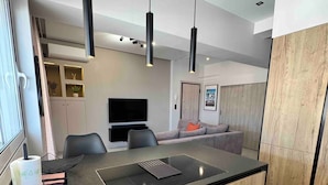A modern kitchen with a central island, black pendant lights, and wooden cabinetry. - Athens Heart Acropolis Balcony (Athens)