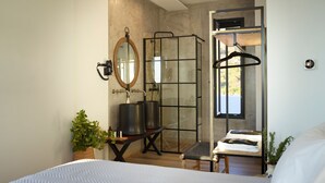 A modern bathroom with a large mirror, two sinks, a shower enclosure, and a hanging towel rack. - Two bedroom villas with private pool (Kalamitsa)
