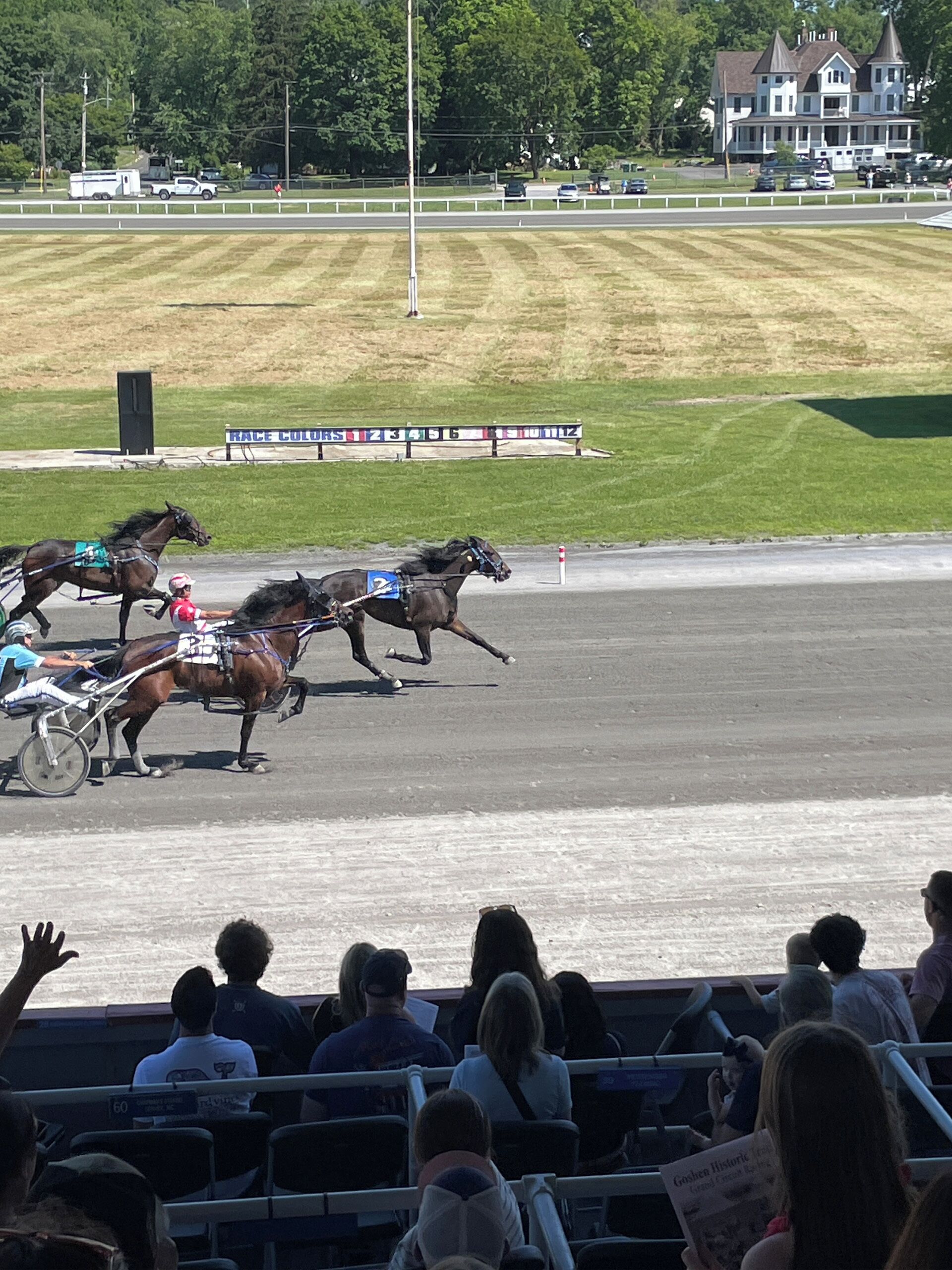 A horse race with spectators in the stands.