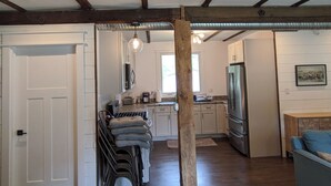 A spacious living area with a kitchen, wooden beams, and a ceiling fan. - Historic Horse Barn Apartment in Goshen (Goshen)