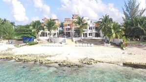 Ein Strandhotel mit klarem Wasser, Palmen und einem Sandstrand.