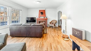 Ein Wohnzimmer mit Kamin, Fernseher und Bücherregal.
