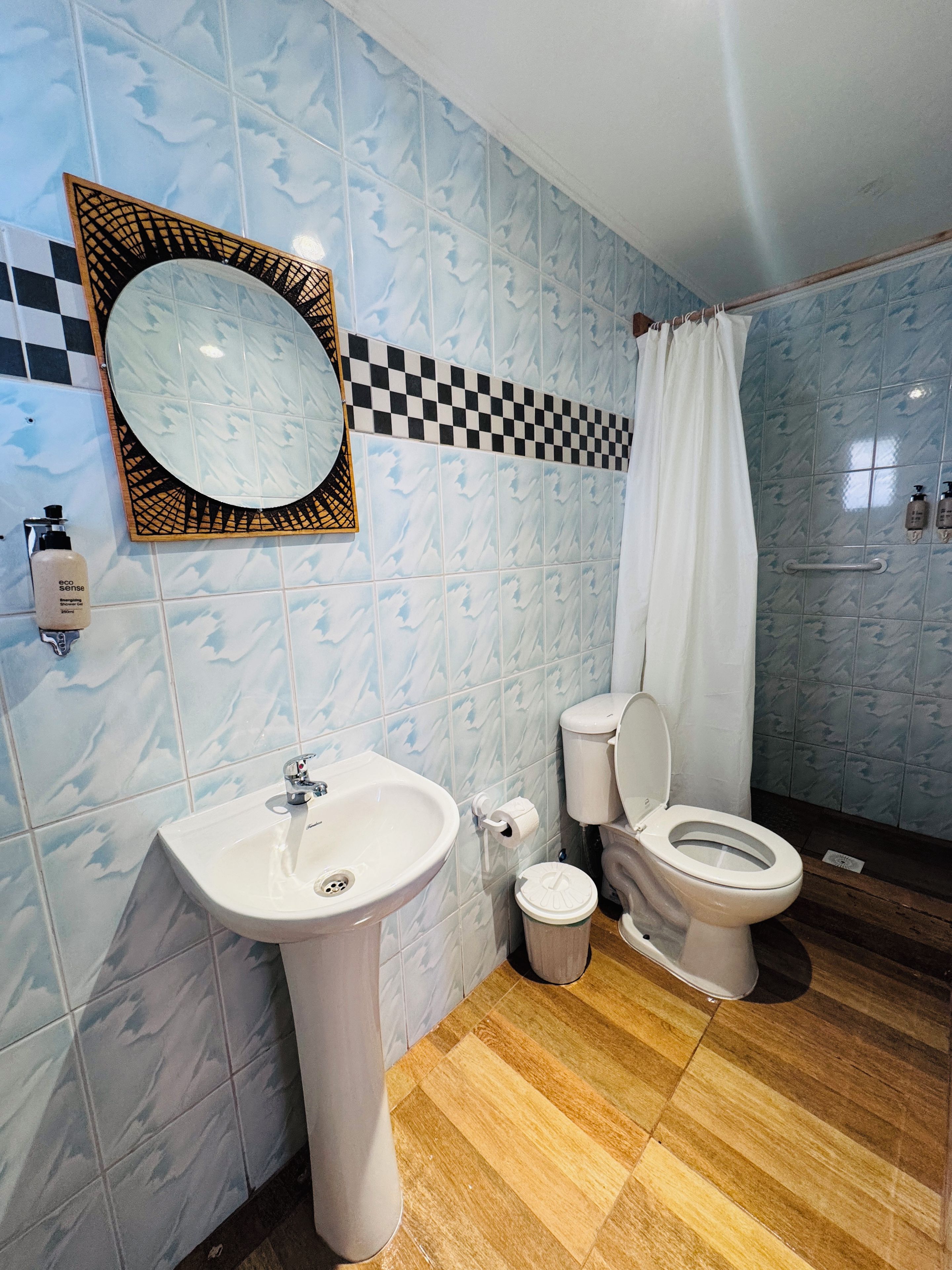 Ein Badezimmer mit Waschbecken, Toilette und Duschvorhang.
