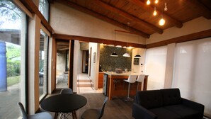 A modern kitchen with a dining area, wooden ceiling, and large windows. - Maceiras House (San Cristóbal de las Casas)