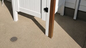 A white gate with black hinges and a wooden post.