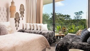 Ein modernes Schlafzimmer mit zwei Betten, einem großen Fenster und Blick auf Grünflächen.