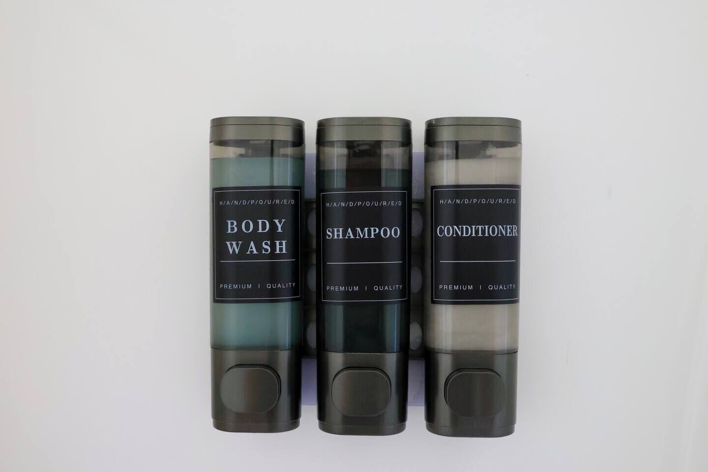 Drie flessen douchegel, shampoo en conditioner.