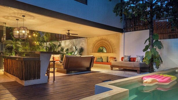 A modern outdoor living area with a pool, wooden deck, seating, and a bar area. - Villa Itze | 5Bdrm Jungle Oasis w/ Pool & BBQ<br>Dedicated concierge<br>Beach access (Tulum)