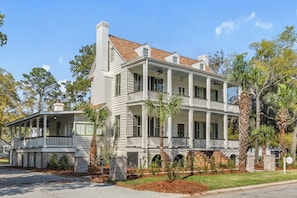 A two-story house with a porch, brick foundation, and a chimney.