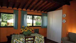 Ruokailutila, jossa on kahdelle katettu pöytä, televisio ja sohva.