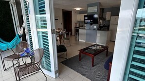 Ein modernes Apartment mit Wohnzimmer, Küche und Balkon.
