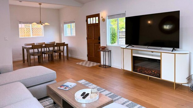 Ett modernt vardagsrum med en soffa, ett soffbord, en tv och en öppen spis.