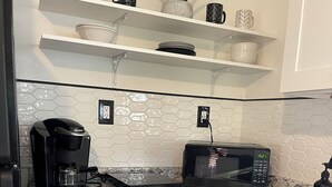 A kitchen with a coffee maker, microwave, and a sink. - Cozy apartment in Valrico (Valrico)