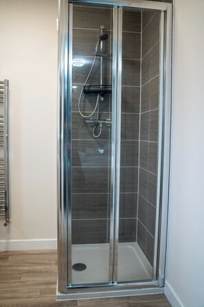 Een douche, handdoeken, zeep, toiletpapier