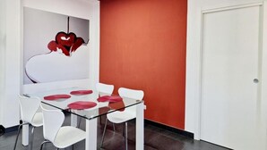 A modern conference room with a glass table, white chairs, and a red accent wall. - Vertigo Casoria (Casoria)