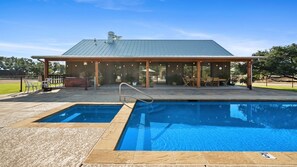 A pool with a covered patio area, a metal roof, and outdoor seating. - Big Groups - Big Memories-Whole Ranch in Graham-34 (Graham)