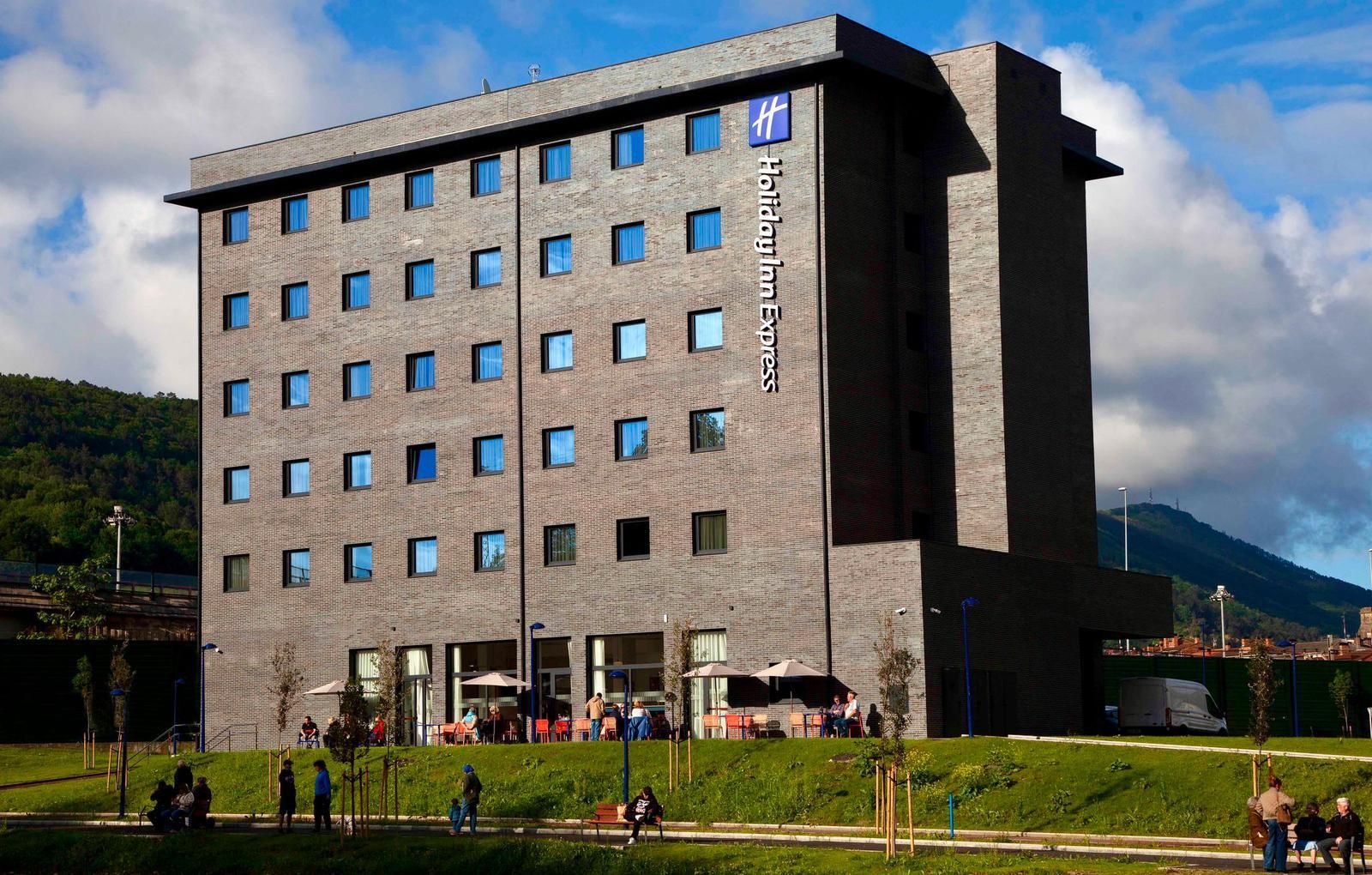 A modern hotel building with a brick facade and multiple windows.