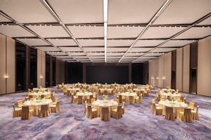 A large banquet hall with round tables and chairs, a patterned carpet, and a high ceiling with lighting fixtures. - Crowne Plaza Suzhou Taihu Lake By Ihg (Suzhou)