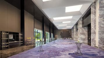 A spacious lobby with a high ceiling, modern furnishings, and a view of the outdoors.