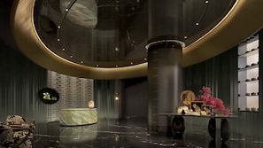 A modern lobby with a curved ceiling, a reception desk, a display of teapots, and a decorative vase with pink flowers. - Crowne Plaza Suzhou Taihu Lake By Ihg (Suzhou)