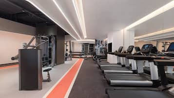A modern gym with treadmills, weight machines, and a running track.