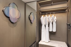 A modern bathroom with a wooden vanity, a mirror, and a towel rack with white robes. - Crowne Plaza Suzhou Taihu Lake By Ihg (Suzhou)