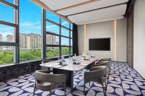 A conference room with a large window, a flat-screen TV, and a city view. - Crowne Plaza Suzhou Taihu Lake By Ihg (Suzhou)