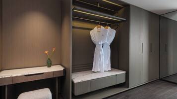 Un vestidor moderno con un banco, una percha para abrigos y un jarrón con flores.