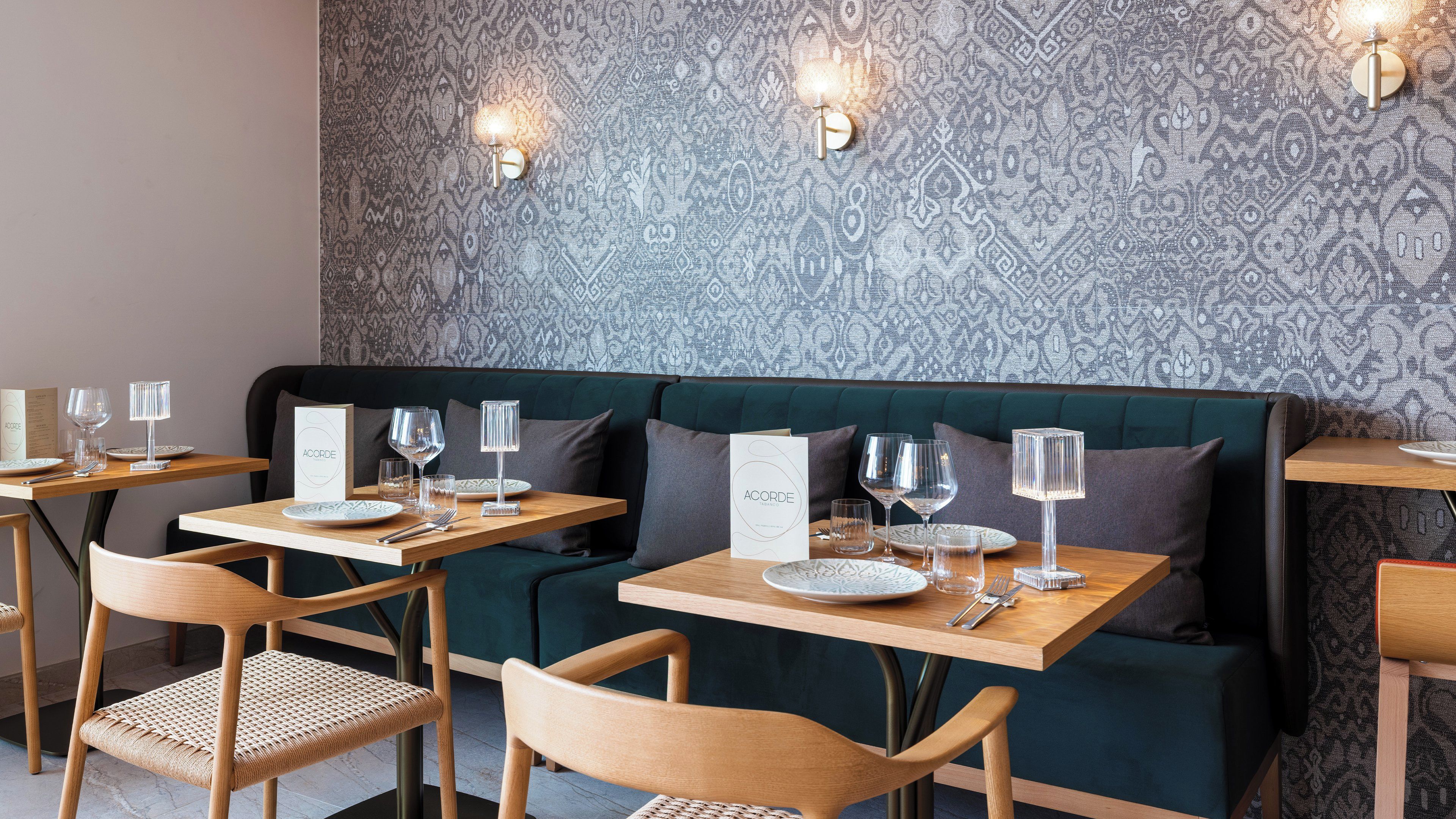 Ein Restaurantinneres mit Wandverkleidung, Holztischen und gepolsterten Sitzmöglichkeiten.