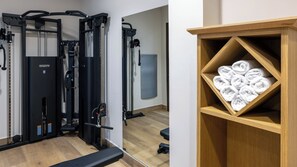 A gym with exercise equipment and a wooden shelf with towels. - Casa Del Compositor, Vignette Collection by IHG (Jerez de la Frontera)
