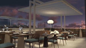 A restaurant with multiple tables and chairs, a large umbrella, and a view of the sky. - Casa Del Compositor, Vignette Collection by IHG (Jerez de la Frontera)