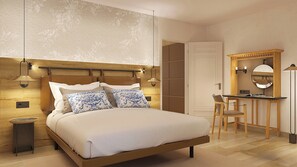 A bedroom with a wooden headboard, bedside lamps, a desk with a chair, and a mirror. - Casa Del Compositor, Vignette Collection by IHG (Jerez de la Frontera)