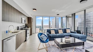 Eine moderne Wohnung mit Küche, Wohnbereich und großen Fenstern mit Blick auf die Stadt.