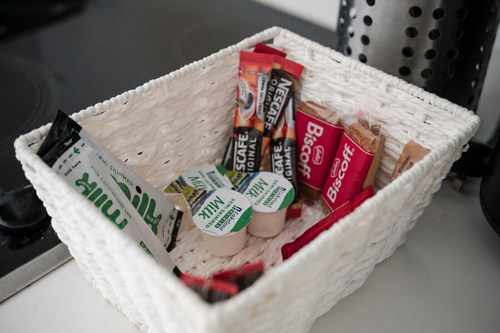 Un panier contenant divers produits alimentaires, notamment du Nescafé, des biscuits et d’autres en-cas.