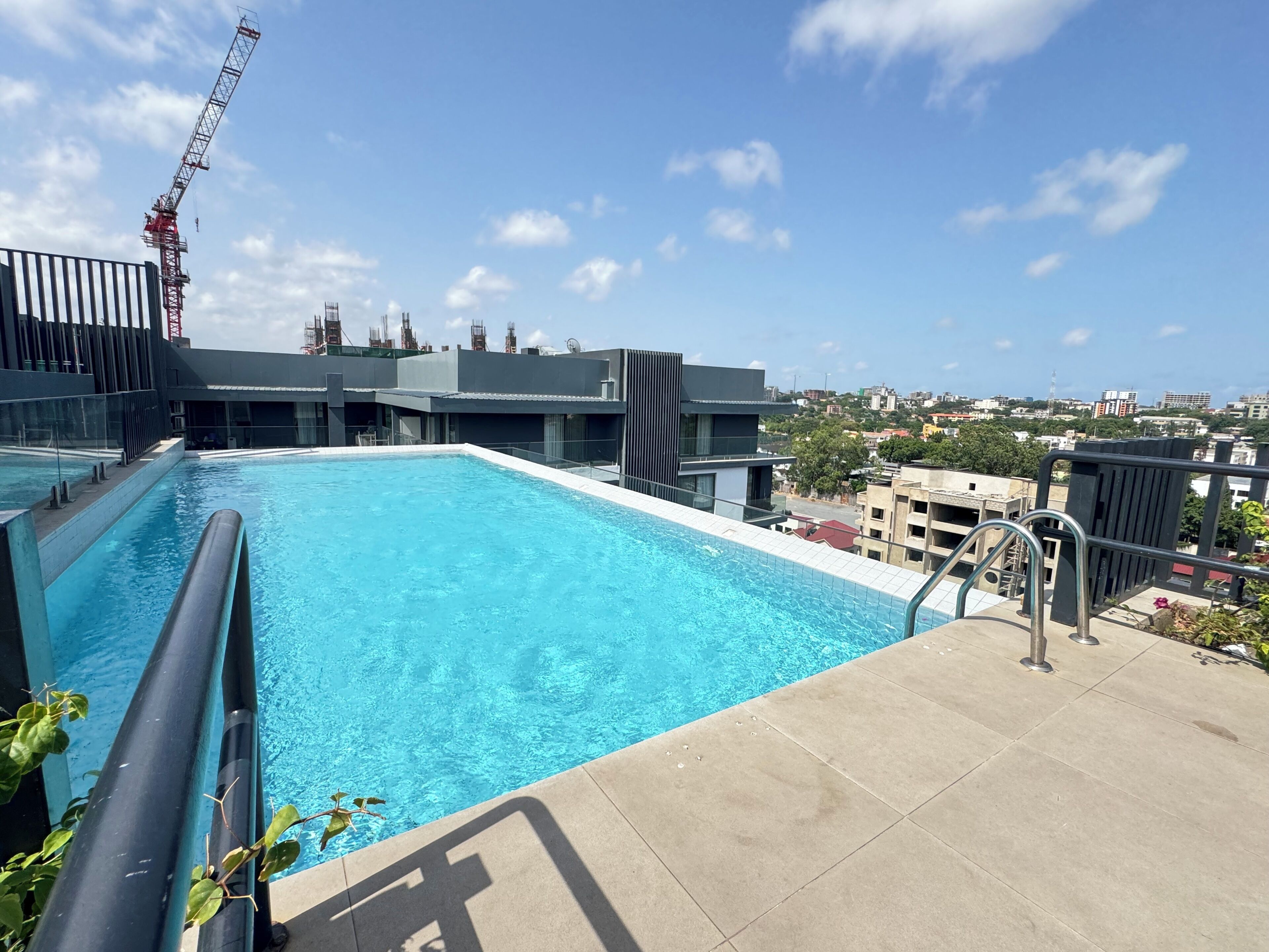 A rooftop pool with a clear view of the cityscape, surrounded by modern buildings.