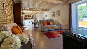 Ein gemütliches Wohnzimmer mit einer Couch, einem Esstisch und einer Küche im Hintergrund.