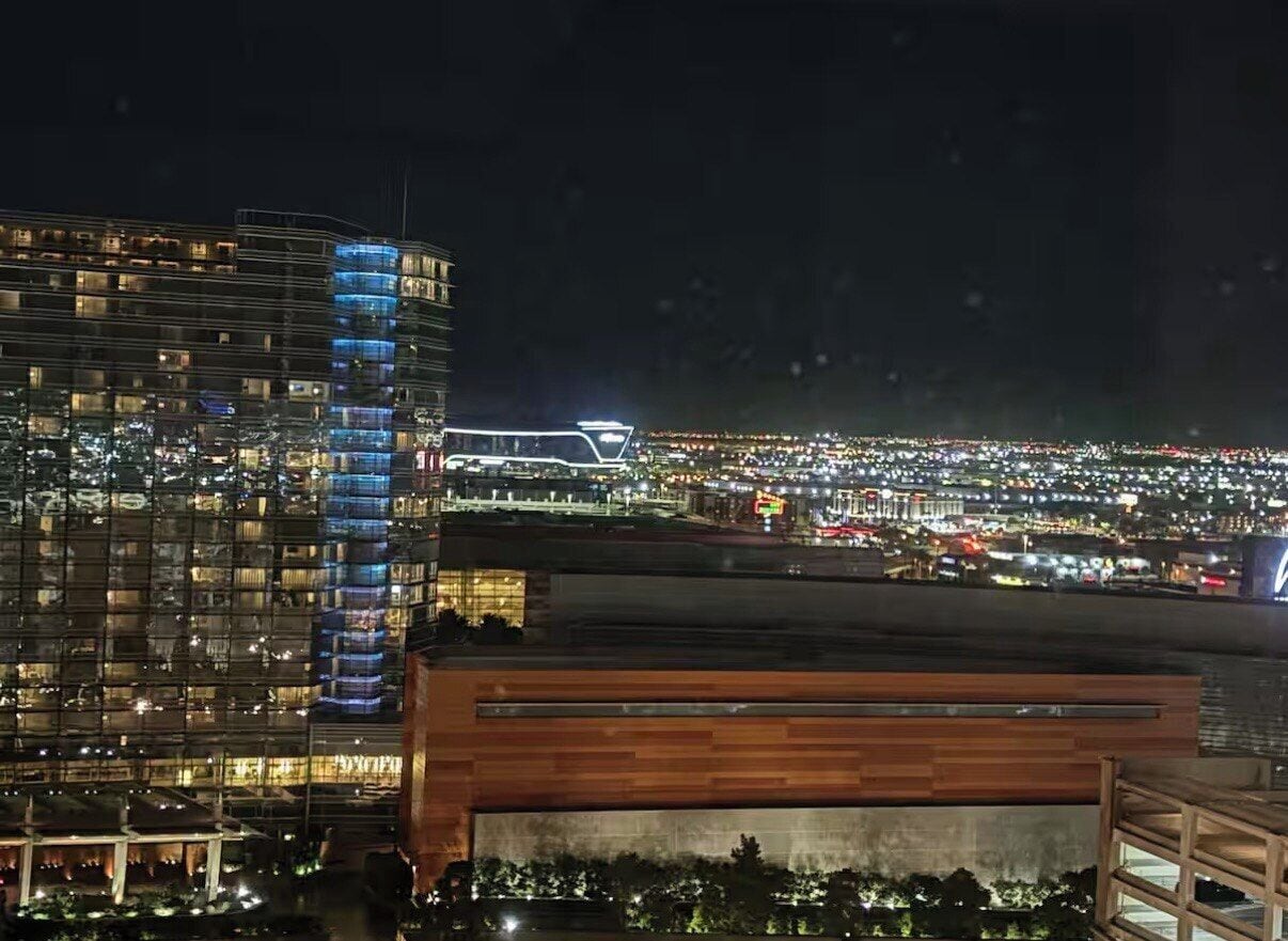 A high-rise hotel with multiple floors, a modern design, and a view of a cityscape at night.