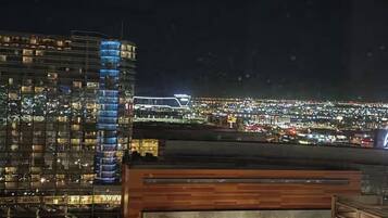 A high-rise hotel with multiple floors, a modern design, and a view of a cityscape at night.