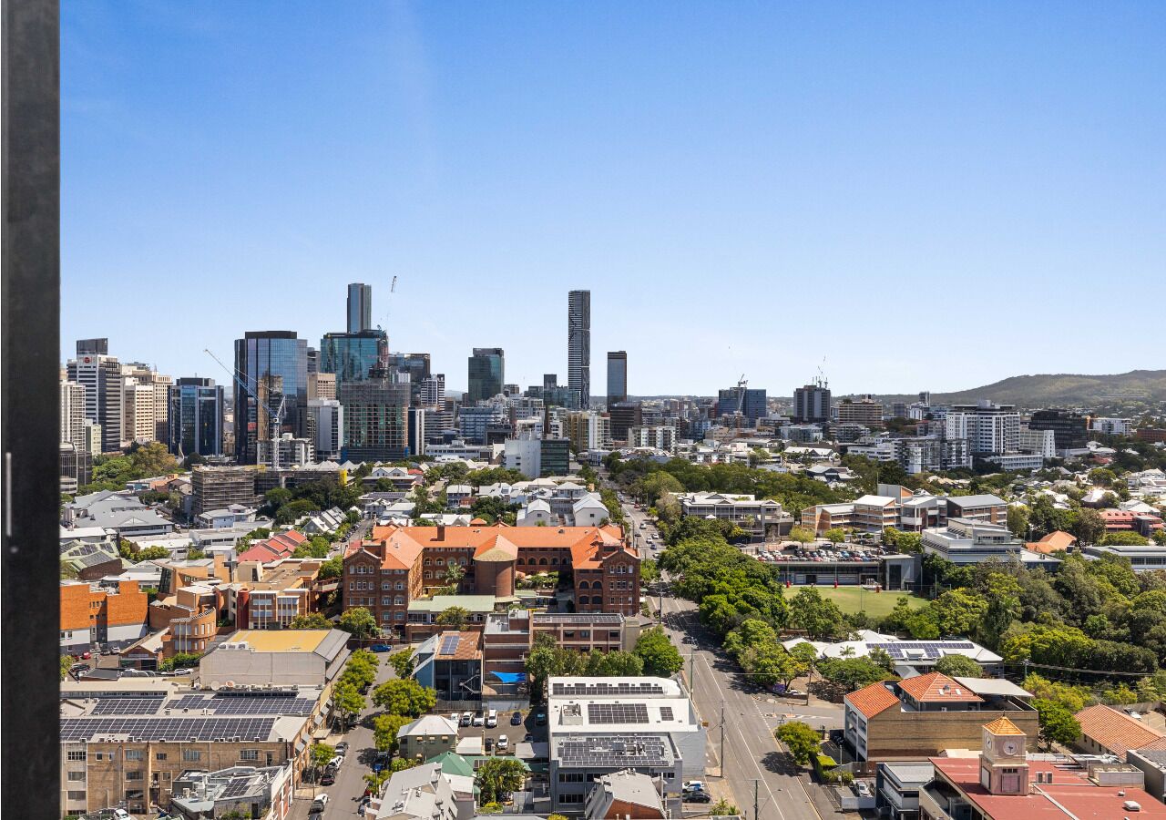 A cityscape with a mix of modern and traditional buildings, including a prominent skyscraper and a variety of residential and commercial structures.