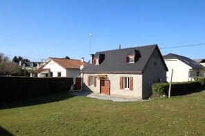 Ein Wohnhaus mit geneigtem Dach, einer Haustür und einer kleinen Veranda.
