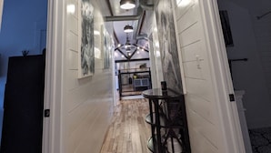 A hallway with wooden flooring, white walls, and a ceiling with exposed ductwork and lighting fixtures. - Hay Loft Apartment in Barn - Goshen (Goshen)