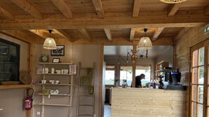 Un interno in legno con una reception, scaffali con oggetti e un estintore.