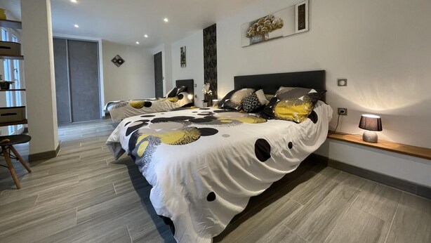 Een moderne slaapkamer met een groot bed, een nachtkastje en een lamp.