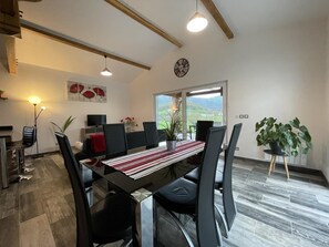 A modern dining area with a table set for six, surrounded by black chairs. There is a large window providing a view of the outdoors. - EKI-BEGIA - AINHICE-MONGELOS (AINHICE-MONGELOS)
