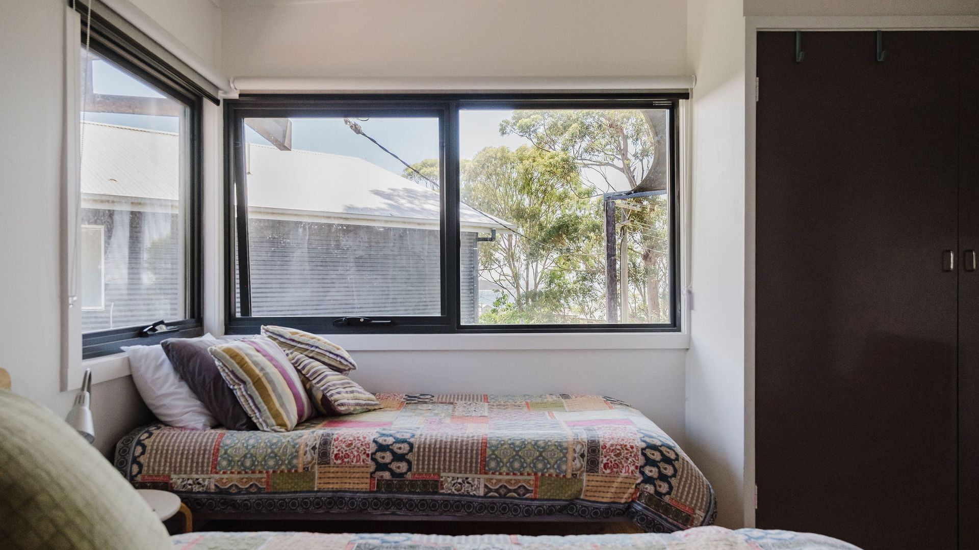 A bedroom with a bed, a window, and a wardrobe.