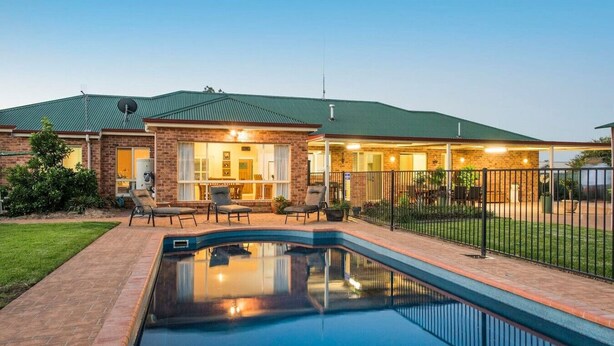 A residential property with a swimming pool, brick patio, and a covered outdoor area with seating. - Resort style villa with pool “Rest Easy Mudgee” (Mudgee)