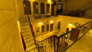Un patio de varios niveles con muros de piedra, una escalera y una barandilla.