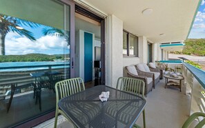 Un balcon avec une table et des chaises, un canapé et un téléviseur.