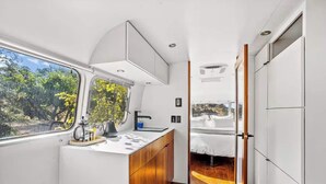 Une cuisine compacte avec une fenêtre, un évier et un petit coin salon.