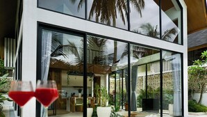 A modern house with large glass windows, a pool, and indoor plants. - Ubud Dzen Villas (Ubud)